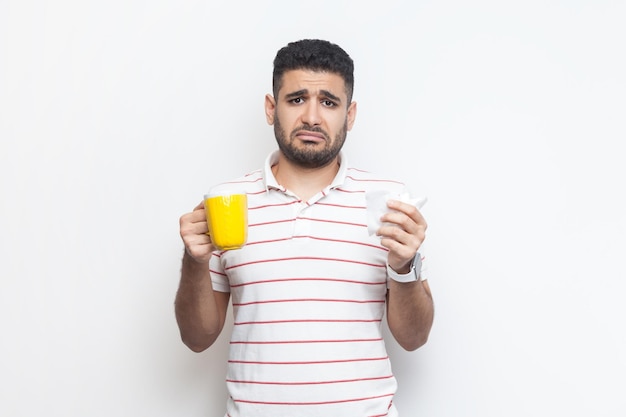 Photo sad unhappy unhealthy man with yellow cup looking at camera feels bad frowning face