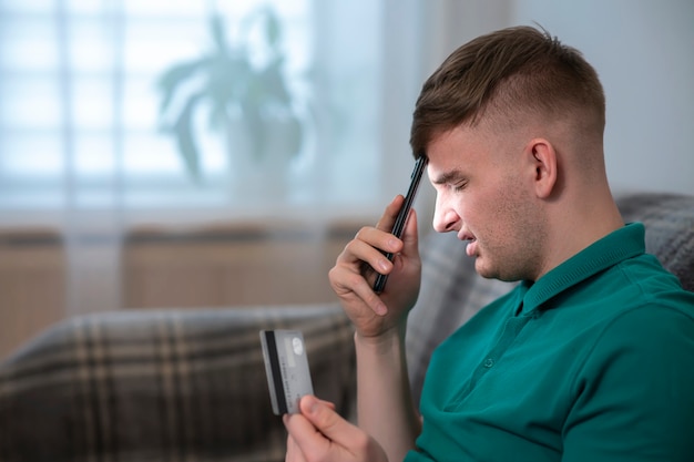 Sad upset angry boy young irritated stressed worried man holding his cell mobile phone and blocked