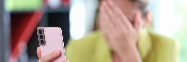 Sad woman covered her face with her hand while reading messages on her mobile phone sad and