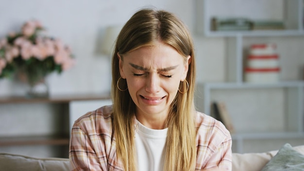 sad woman crying on the sofa at home