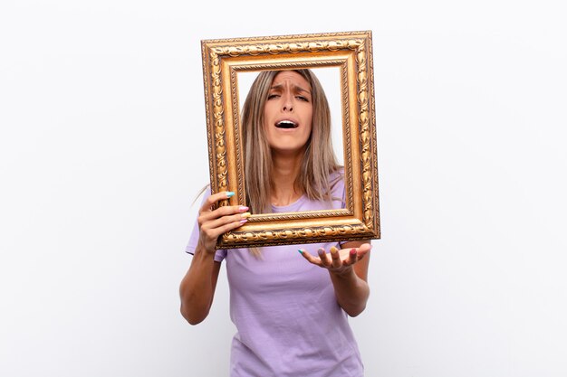 sad woman behind golden frame