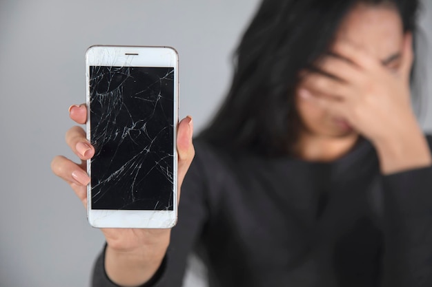 Sad woman hand broken phone