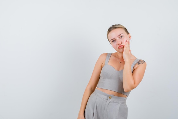 The sad woman is thinking by putting he rhand on cheek on white background