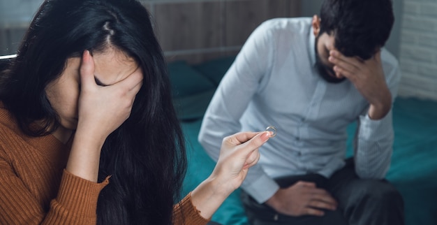 Sad woman and man hand ring in room