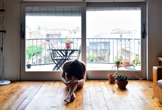 A sad woman naked in her house