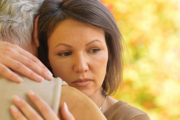 Photo sad woman and senior man hugging