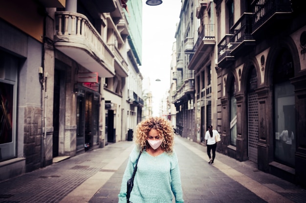 Sad woman stand in the. middle of the road in the city wearing protection coronavirus mask 