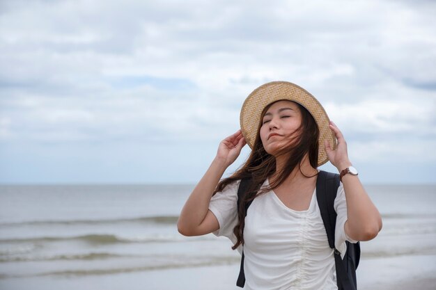 Una donna triste in piedi da sola in riva al mare
