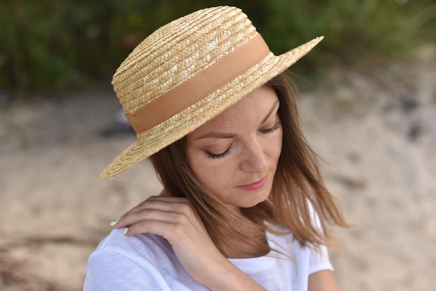 Sad woman in straw hat with ribbon walk outdoor portrait of tender girl with downcast eyes miss home