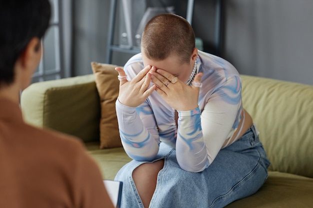 Sad woman visiting psychologist in office