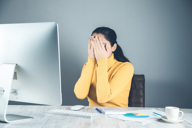 Sad woman with computer and graph in office