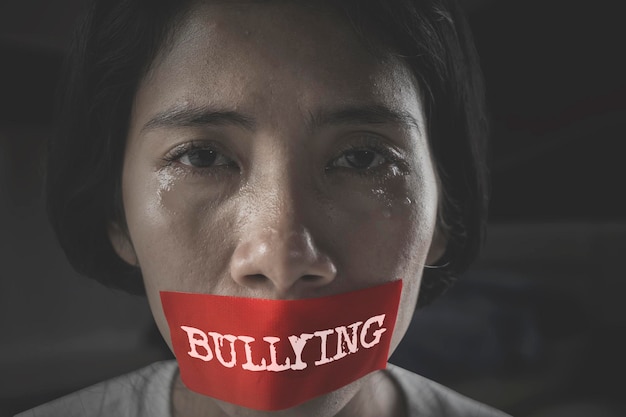 Photo sad woman with mouth covered by bullying word