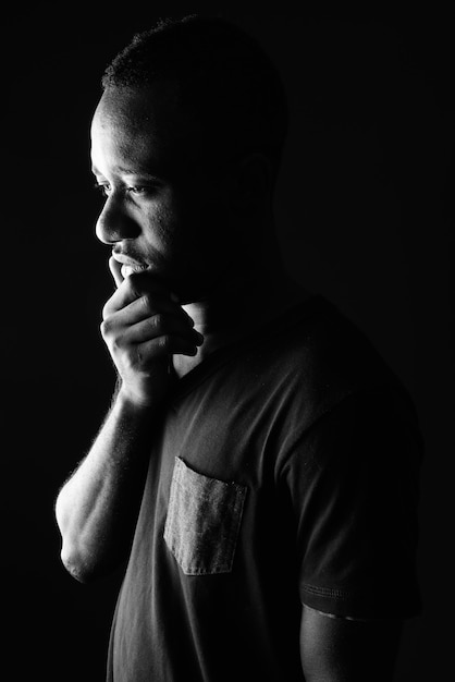 Sad young African man profile view thinking in black and white