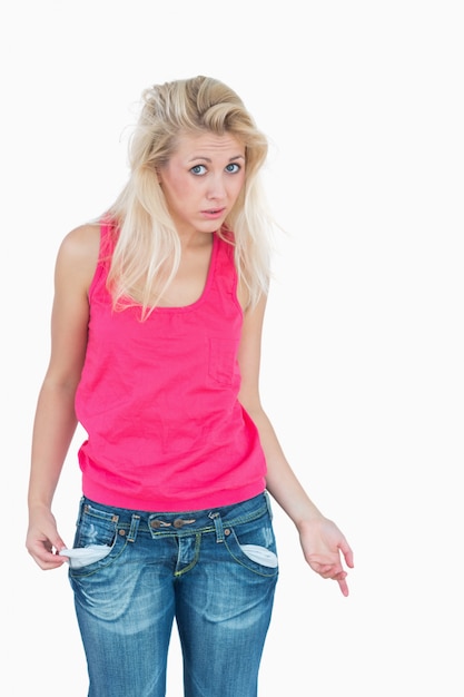 Photo sad young female showing her empty pockets