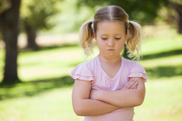 悲しみの若い女の子が公園に横たわった