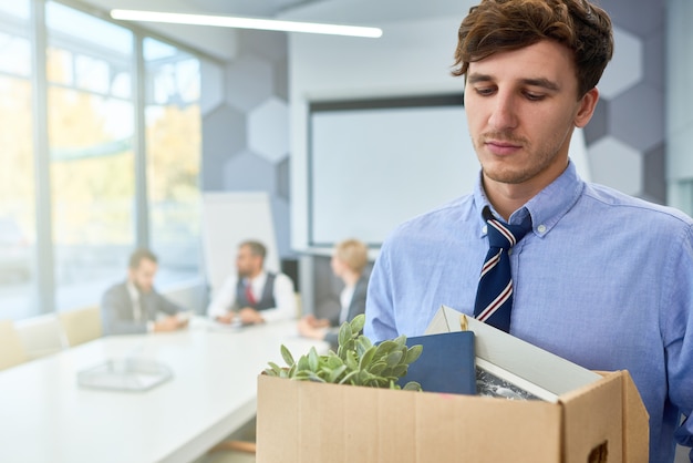 Photo sad young man leaving job