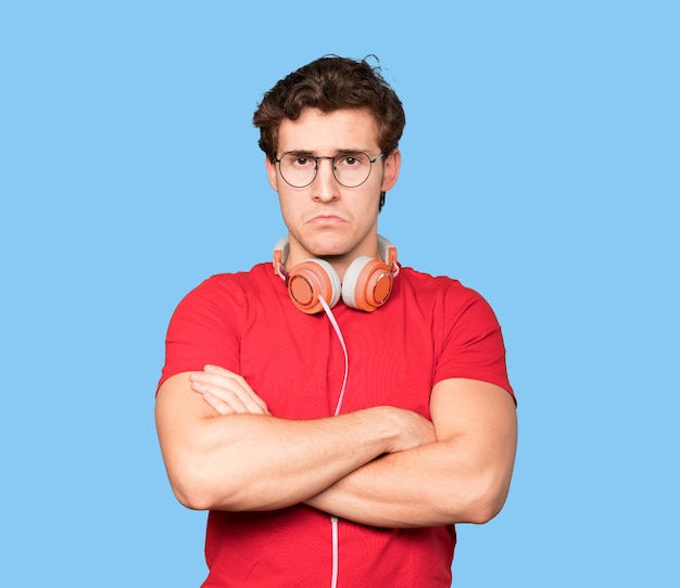 Sad young man using headphones