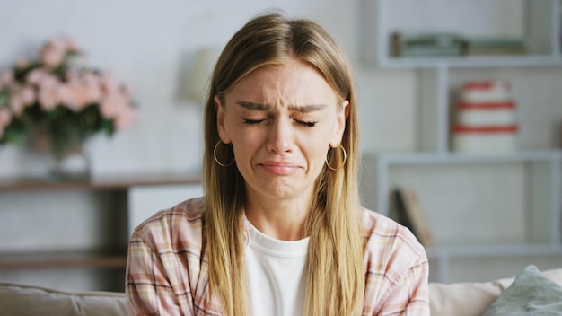 sad young woman crying on the sofa at home