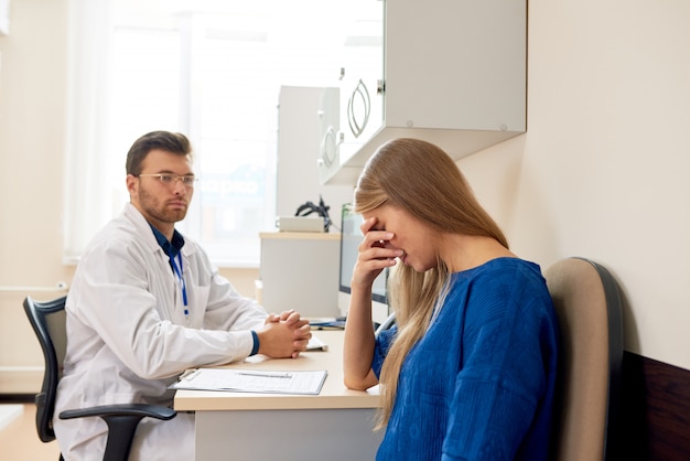 Sad Young Woman in Doctors Office