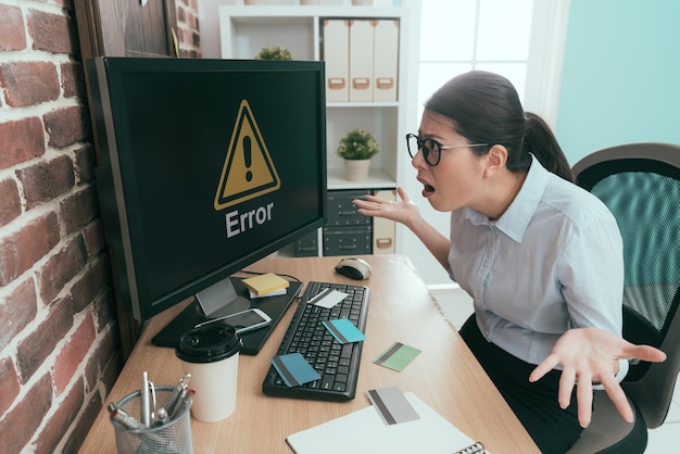 Foto tristezza ufficio lavoratore signora che mostra confusa posa e guardando le informazioni di errore del computer perché tutte le sue carte di credito hanno rubato.