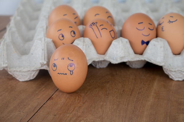 Sadness on wedding Eggs face action on egg-shell in brown paper box.