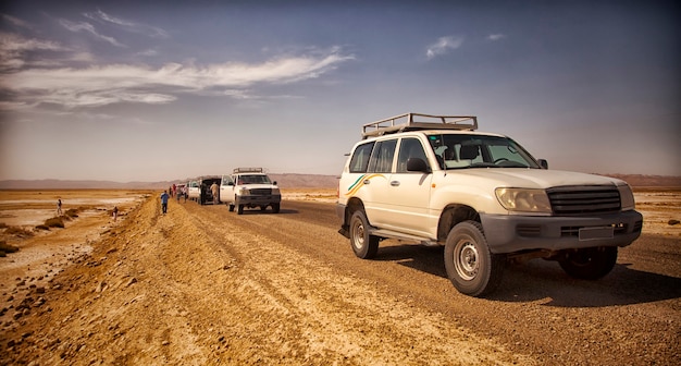 Safari e viaggi in africa, avventure estreme nel deserto del sahara. una jeep in panne sotto il sole cocente in mezzo a una palude salata, una strada deserta e fuoristrada.