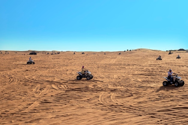 Safari con atv nel paesaggio di sabbia del deserto arancione delle dune di sabbia