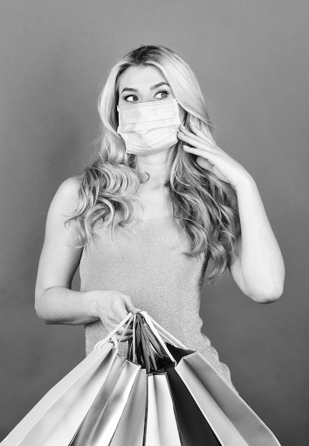 Foto donna dello shopping sicura e sana in maschera respiratoria con sacchetti di carta shopper proteggersi dallo scoppio della pandemia di coronavirus acquisto di maschera medica quarantena del virus del concetto di deficit epidemico