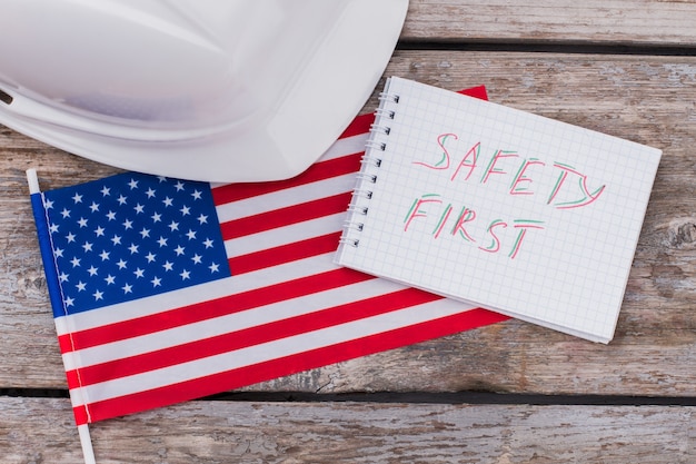 미국 건설 노동자의 안전. 미국 국기와 헬멧이 달린 메모장.
