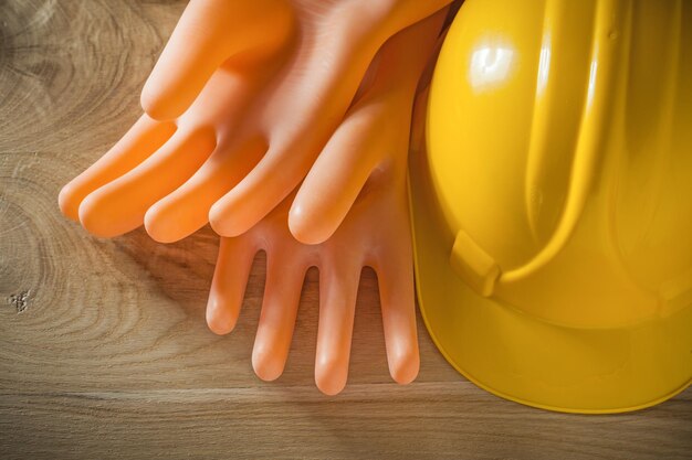 Safety building helmet electricians gloves on wood board.