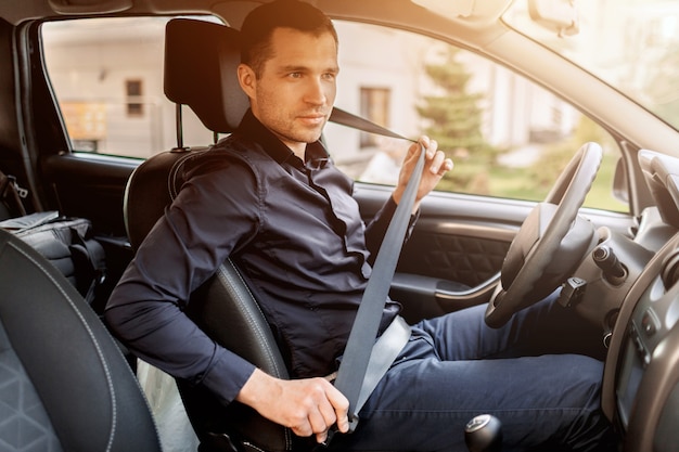 Safety driving concept. a man fastens his seat belt. before driving