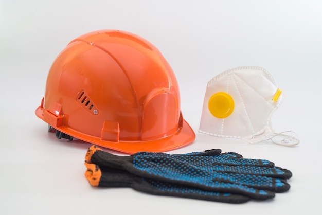 Safety equipment with helmet, respirator, ear plugs and gloves isolated on white. Means of protection for a large industrial enterprise.