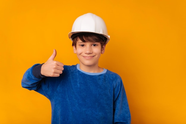 Safety first says a teen boy wearing white hard hat and showing thumb up