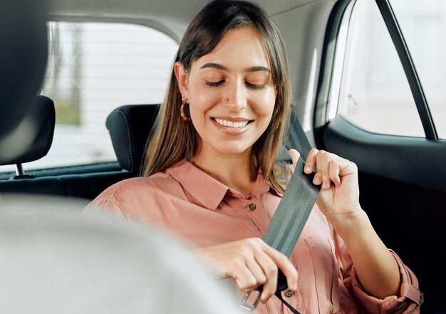 安全は私に笑顔を与える若い女性が車の中でシートベルトを締めているショット