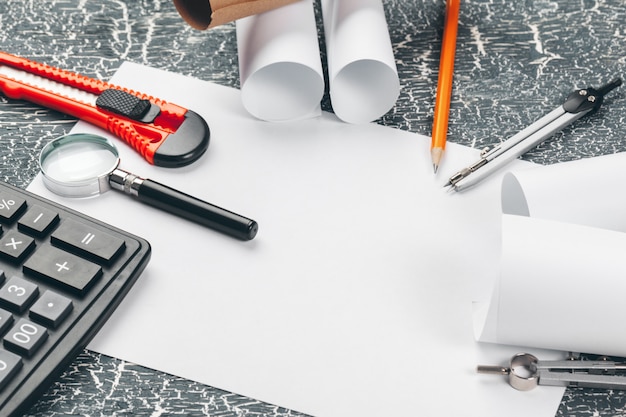 safety helmet and Scrolls of engineering drawings and supplies