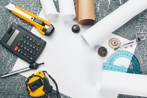 safety helmet and Scrolls of engineering drawings and supplies