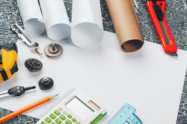 safety helmet and Scrolls of engineering drawings and supplies