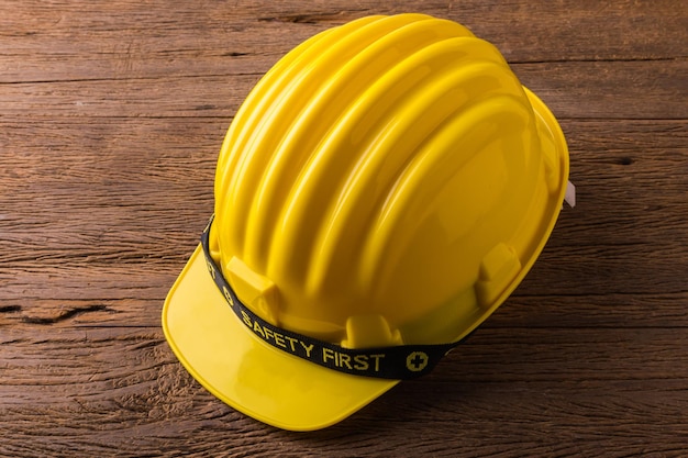 safety helmet on wooden table and note book