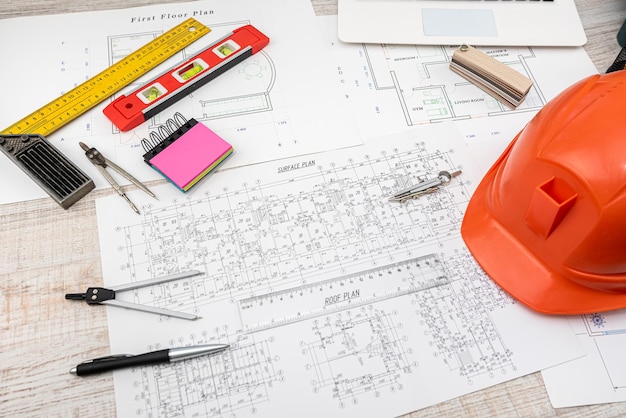 Safety helmet wort tools on house drawing of blueprint