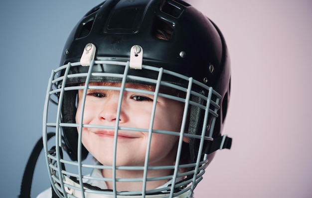 Safety and protection. Protective grid on face. Sport equipment. Hockey or rugby helmet. Sport childhood. Future sport star. Sport upbringing and career. Boy cute child wear hockey helmet close up