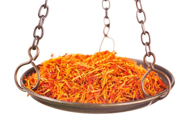 Saffron in old balance scale on white background