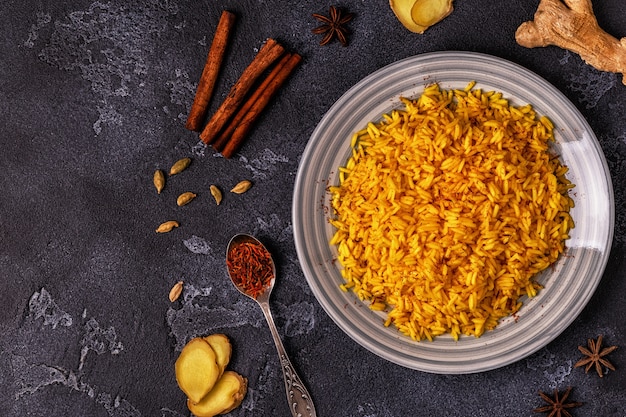 Saffron rice with spices on dark table