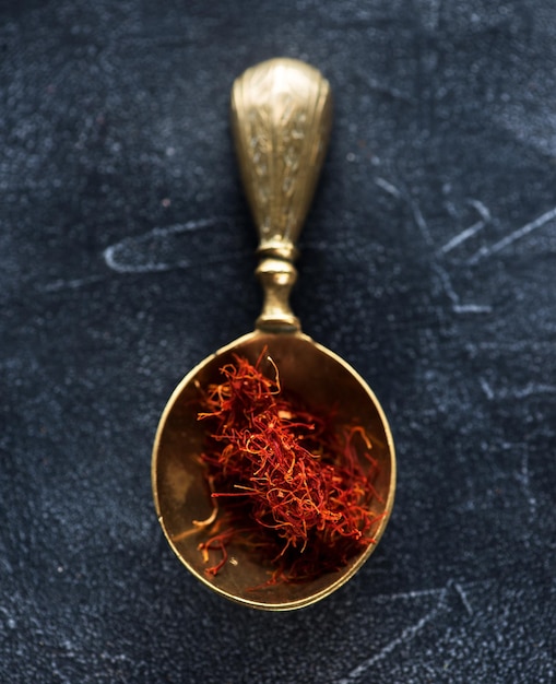 Saffron Spice. Saffron spices in a brass spoon. Indian spice top view. Seasonings, condiments. Cooking ingredients, flavor