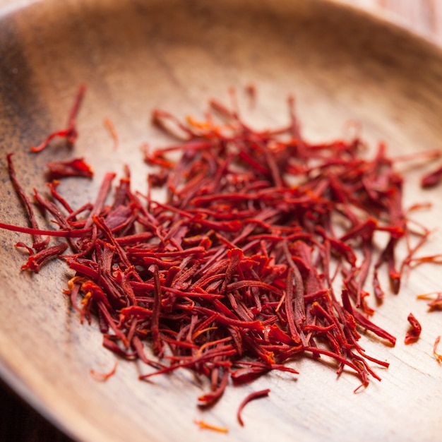 Photo saffron spice in the wooden spoon close up