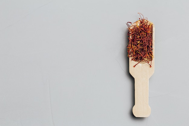 Saffron in a spoon on a gray background