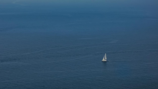 Foto barca a vela da solo su un mare calmo