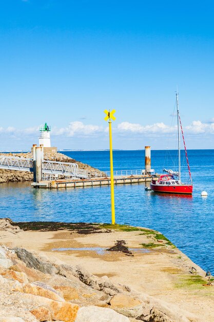 Foto barca a vela sulla spiaggia contro il cielo blu