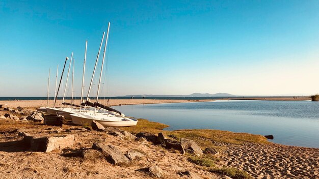 Sailboat on beach against clear blue sky