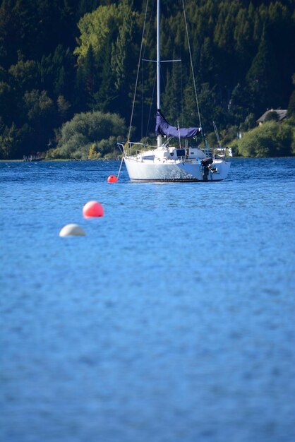 sailboat in the center of a lake with blue waters