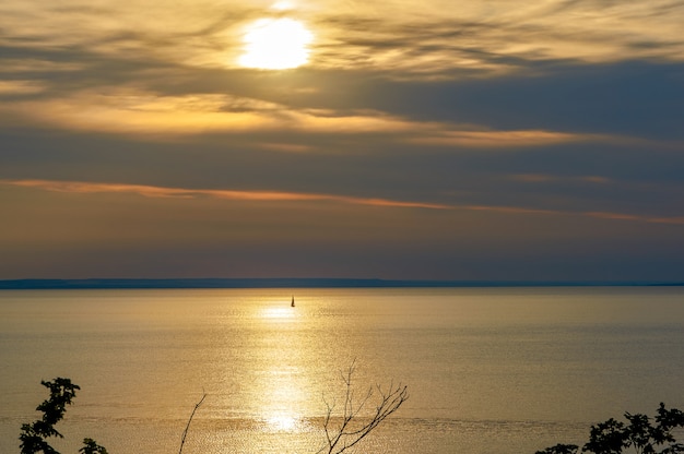 Sailboat in the distance at sunset in the ocean